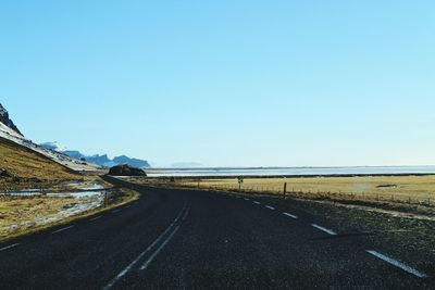 Road on landscape against clear blue sky