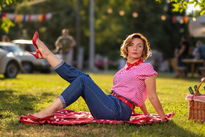 Portrait of young woman sitting on field