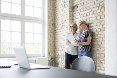 Mature businesswoman working with younger colleague in office