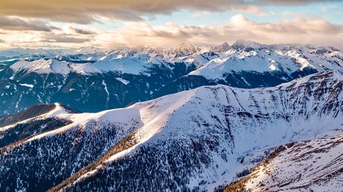 Aerial view of snowcapped mountains against sky during winter