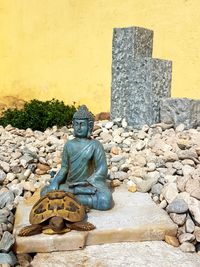 Statue against stone wall