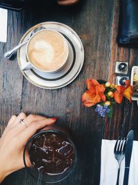 Cropped hand of woman having drink at table