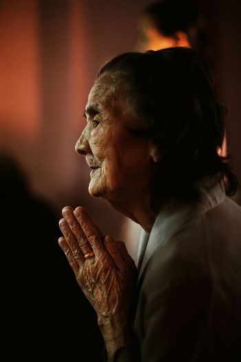 Side view of senior woman with hands clasped