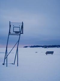 Lifeguard hut on snow covered field against sky