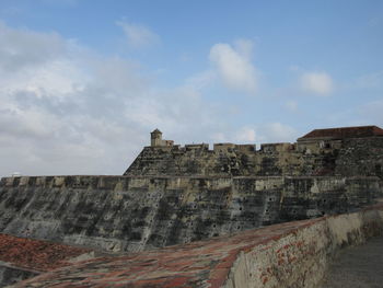 Low angle view of fort against cloudy sky