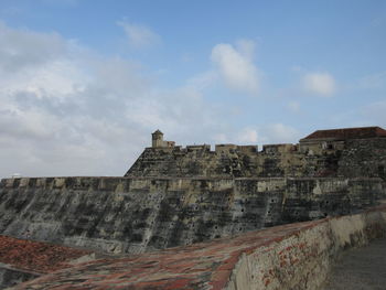 Low angle view of fort against cloudy sky