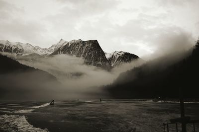 Scenic view of lake and snowcapped mountains against sky