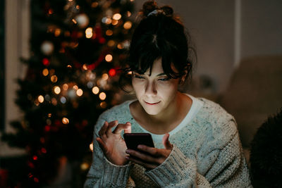 Young woman using mobile phone at home