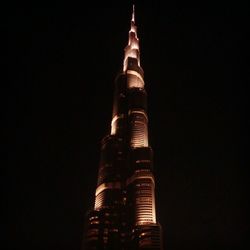 Low angle view of illuminated tower at night