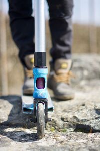 Low section of man with push scooter on footpath 