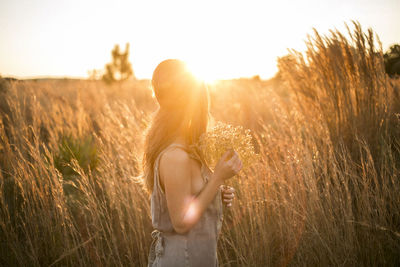 Side view of woman standing at grassy field