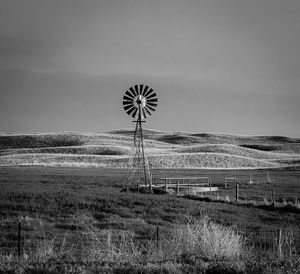 Windmill on field against sky