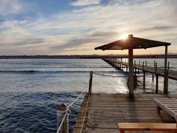 Pier over sea against sky during sunset