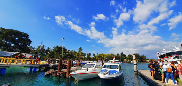 Boats moored in canal against sky