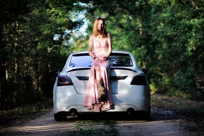 Woman wearing sunglasses standing against car