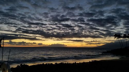 Scenic view of sea against dramatic sky during sunset