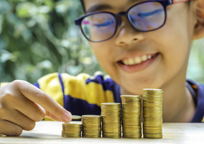 Close-up of boy stacking coins on table