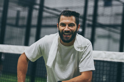 Beautiful man playing padel tennis, smiling after a win. young sporty boy at the end of the match