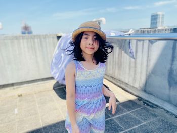 Portrait of young woman standing against wall