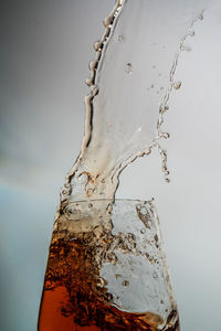 Close-up of water drops on glass against white background