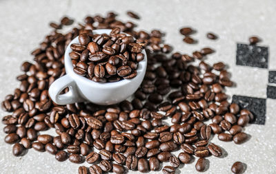 Close-up of coffee cup with beans on table