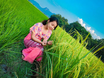 Young woman sitting on field