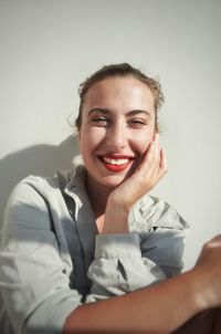 Portrait of young woman against wall