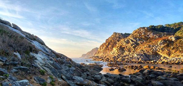 Scenic view of sea by rock formation against sky