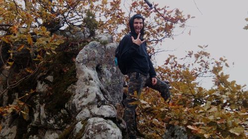 Portrait of man on rock during autumn
