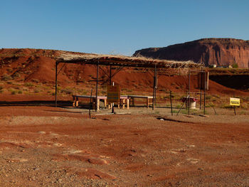 Shed by rock formations at desert against sky