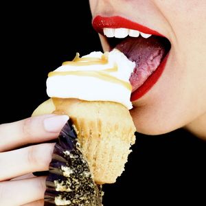 Close-up of hand holding ice cream over white background