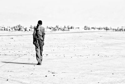 Rear view of woman walking on beach