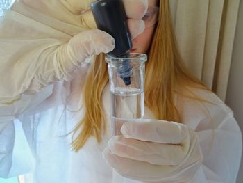 Close-up of girl pouring chemical in test tube