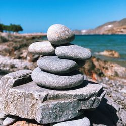 Close-up of pebble stones stack against sky