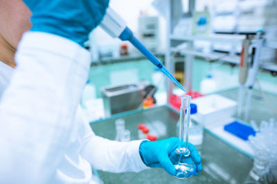 Midsection of scientist experimenting at laboratory