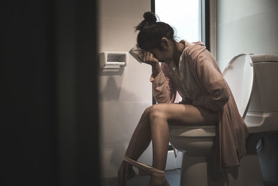 Young woman sitting on chair at home