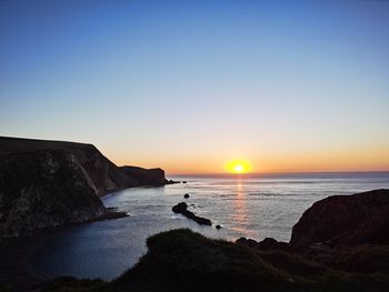 Scenic view of sea against clear sky during sunset