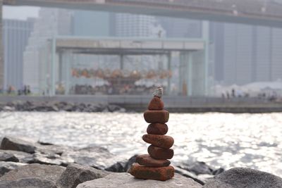 Stack on stones by river in city during sunny day