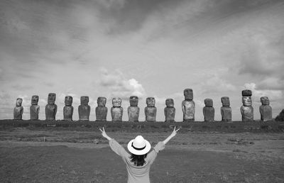 Monochrome of happy female visitor in front of moai statues of ahu tongariki, easter island, chile