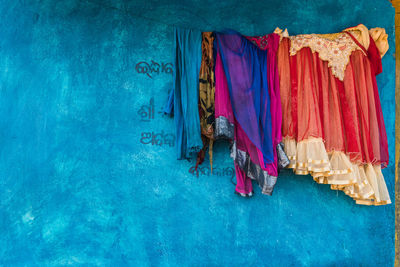 Panoramic view of multi colored clothes hanging on blue background