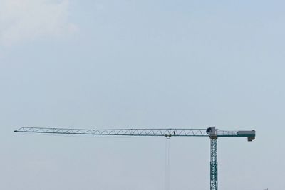 Low angle view of crane against sky