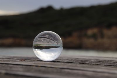 Close-up of crystal ball on wooden surface