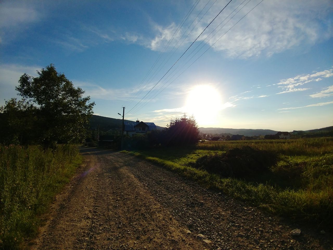 sky, plant, cloud - sky, road, tranquil scene, nature, tranquility, sunlight, scenics - nature, tree, field, land, grass, beauty in nature, landscape, no people, environment, the way forward, direction, sun, outdoors, lens flare