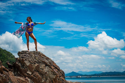 Full length of woman on rock against sky