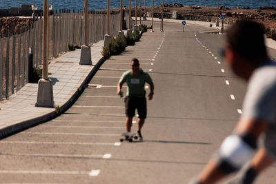 Rear view of man walking on footpath