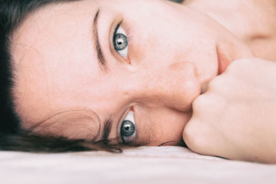 Close-up of woman lying on bed at home
