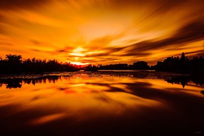 Scenic view of lake against orange sky