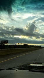 Road by landscape against sky during sunset