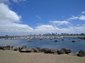 Sailboats on sea shore against sky