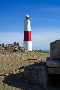 Lighthouse by sea against sky